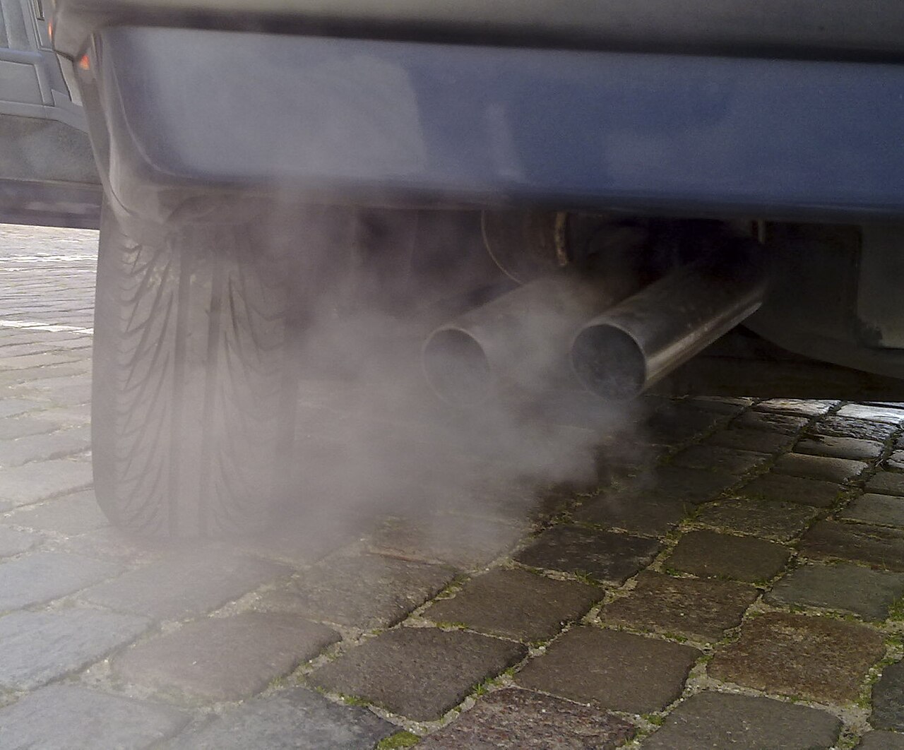 Close up of a car exhaust pipe and a cloud of gas emissions.