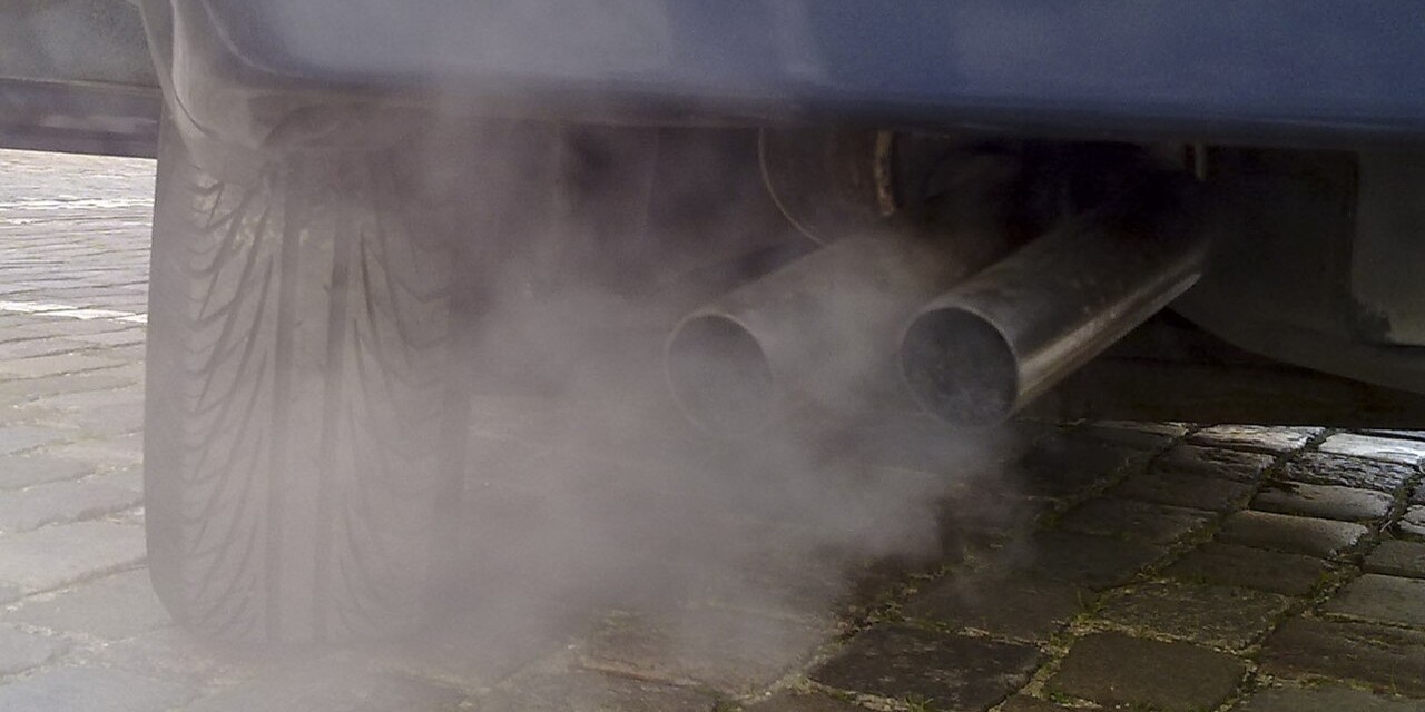Exhaust exits the tailpipe of an idling car.