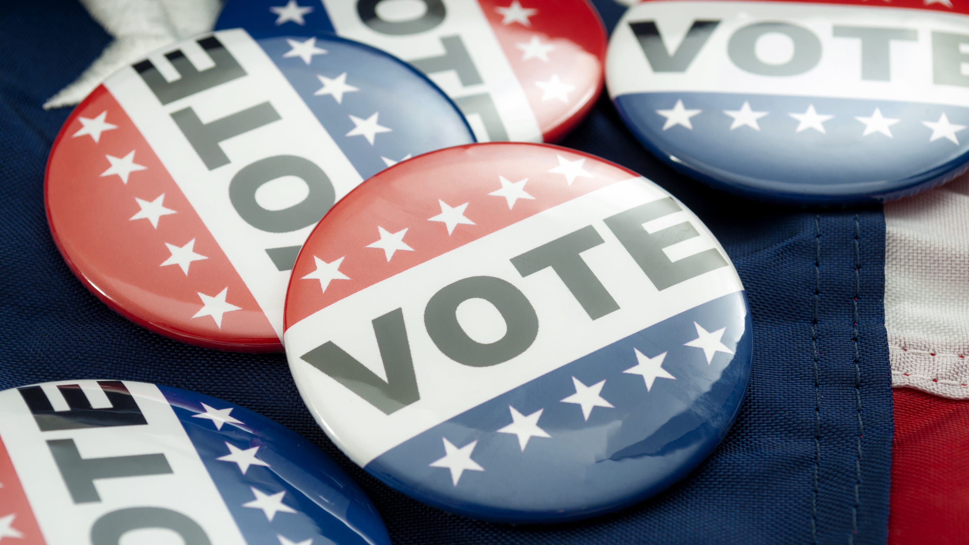 Multiple pins with the word 'Vote' on them