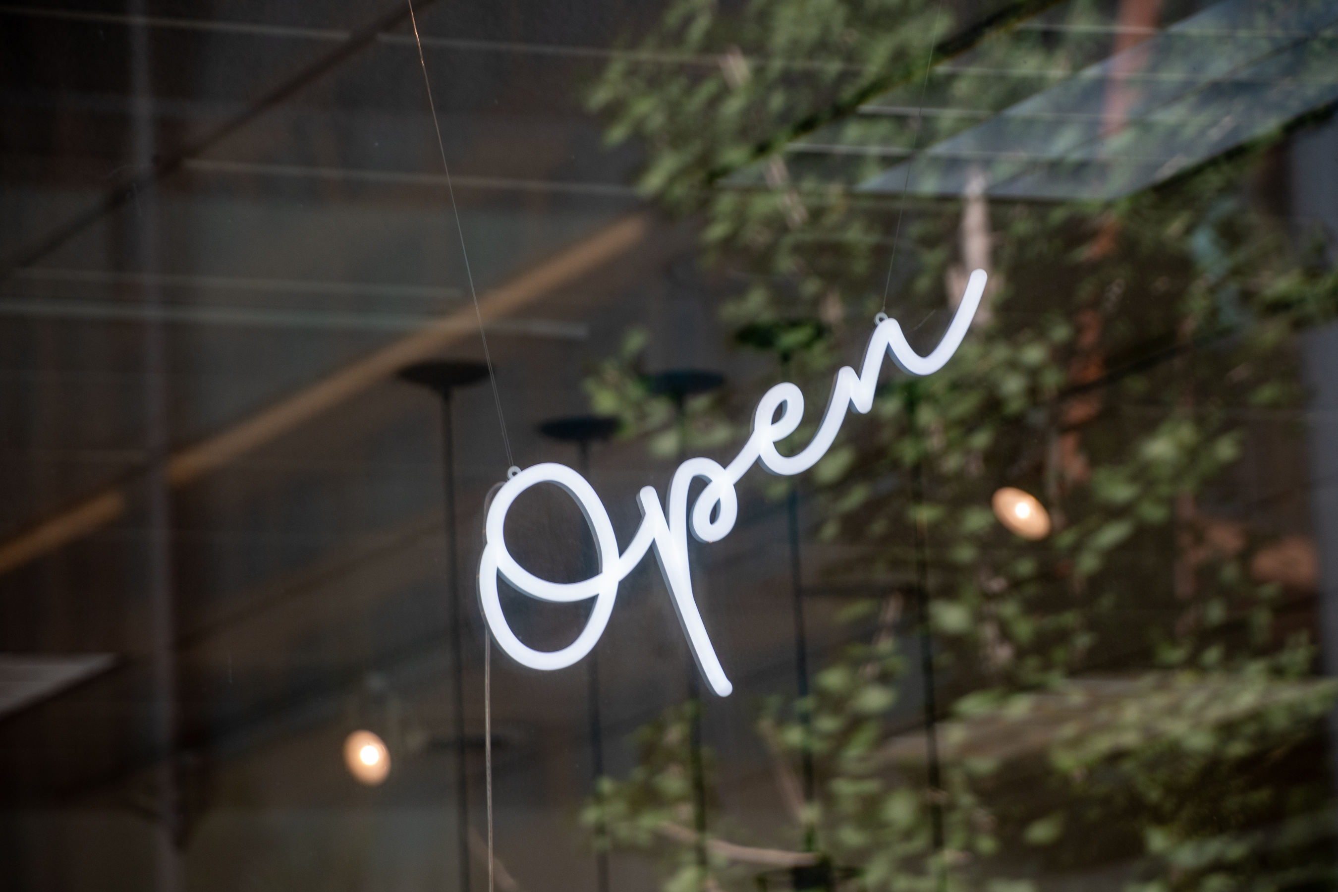a white neon open sign in the window of an undefined business