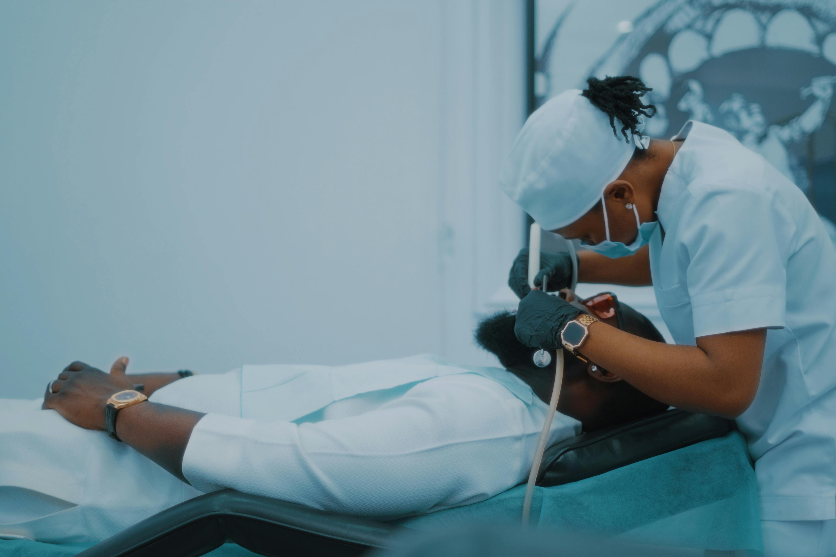 a dentist working on a patient in a white sterile room
